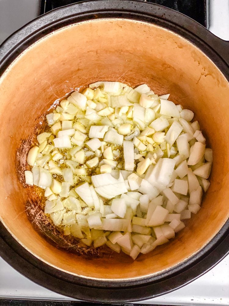 process shot showing onions and garlic cooking in a pan