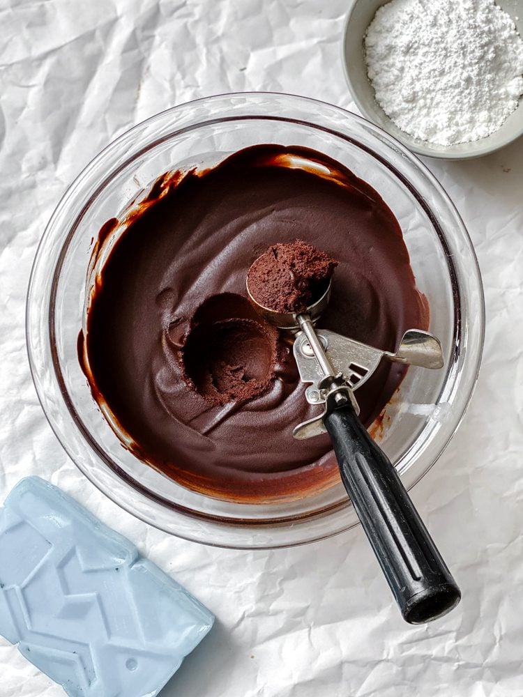 Process shot showing scooping chocolate mixture with scooper.