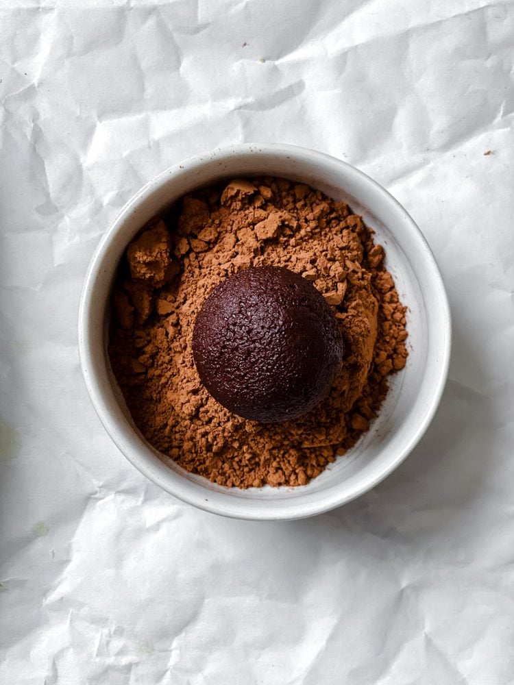 Process shot showing rolling ball in cocoa powder.