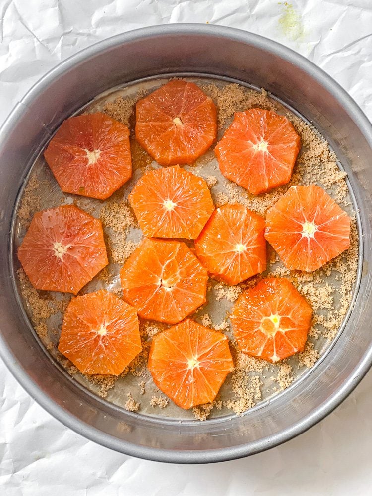 process shot showing adding orange slices to baking dish