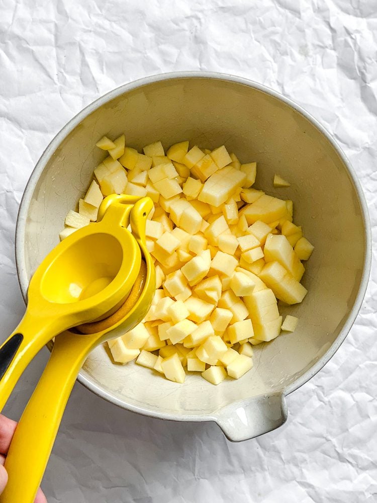 Process shot showing adding lemon juice to bowl.