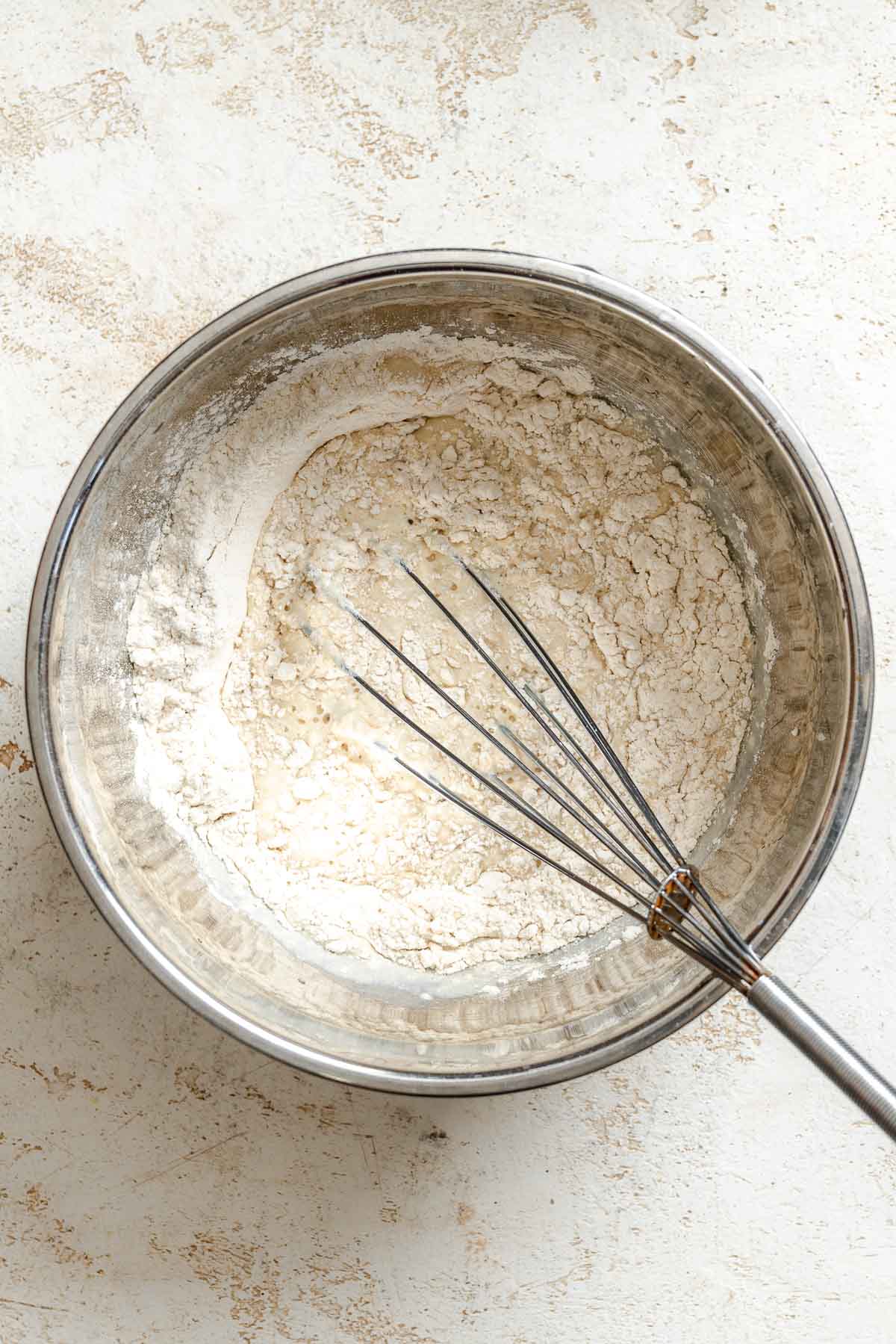 Process shot showing whisking batter in a bowl.