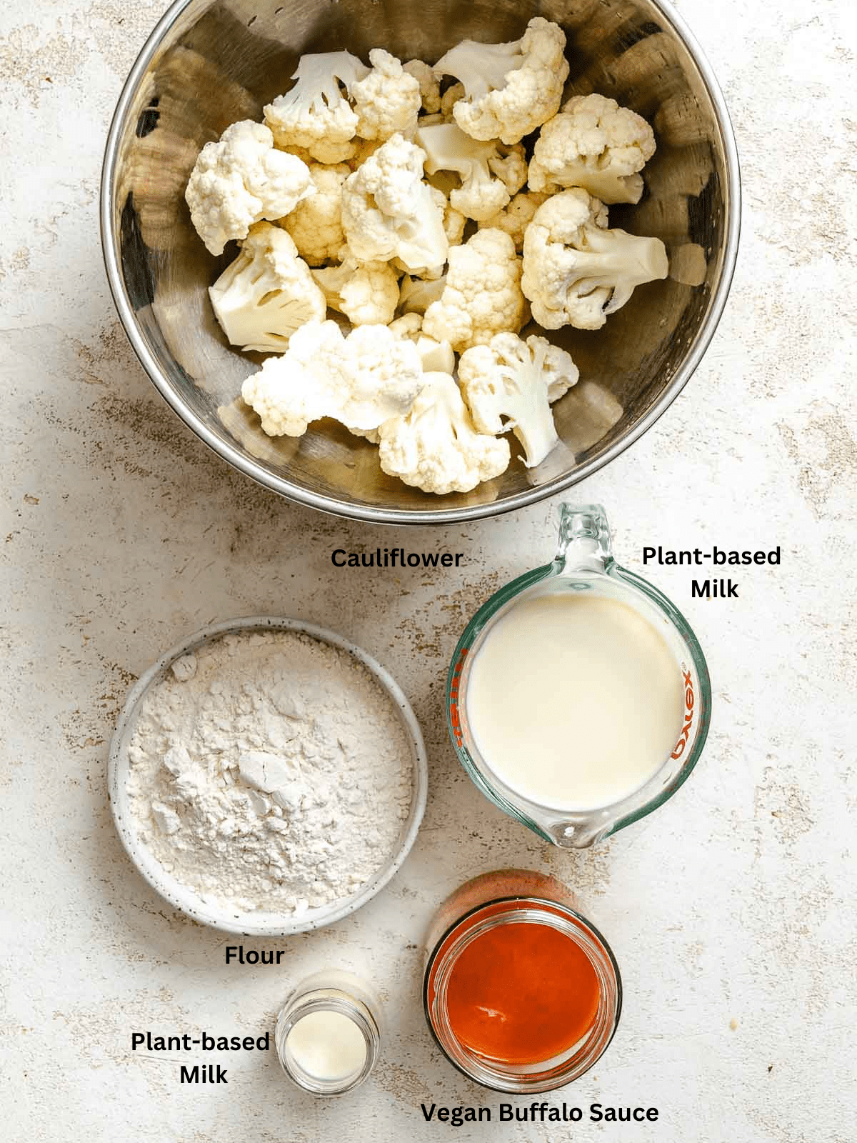 Ingredients for Air Fryer Buffalo Cauliflower Wings measured out on a white surface.