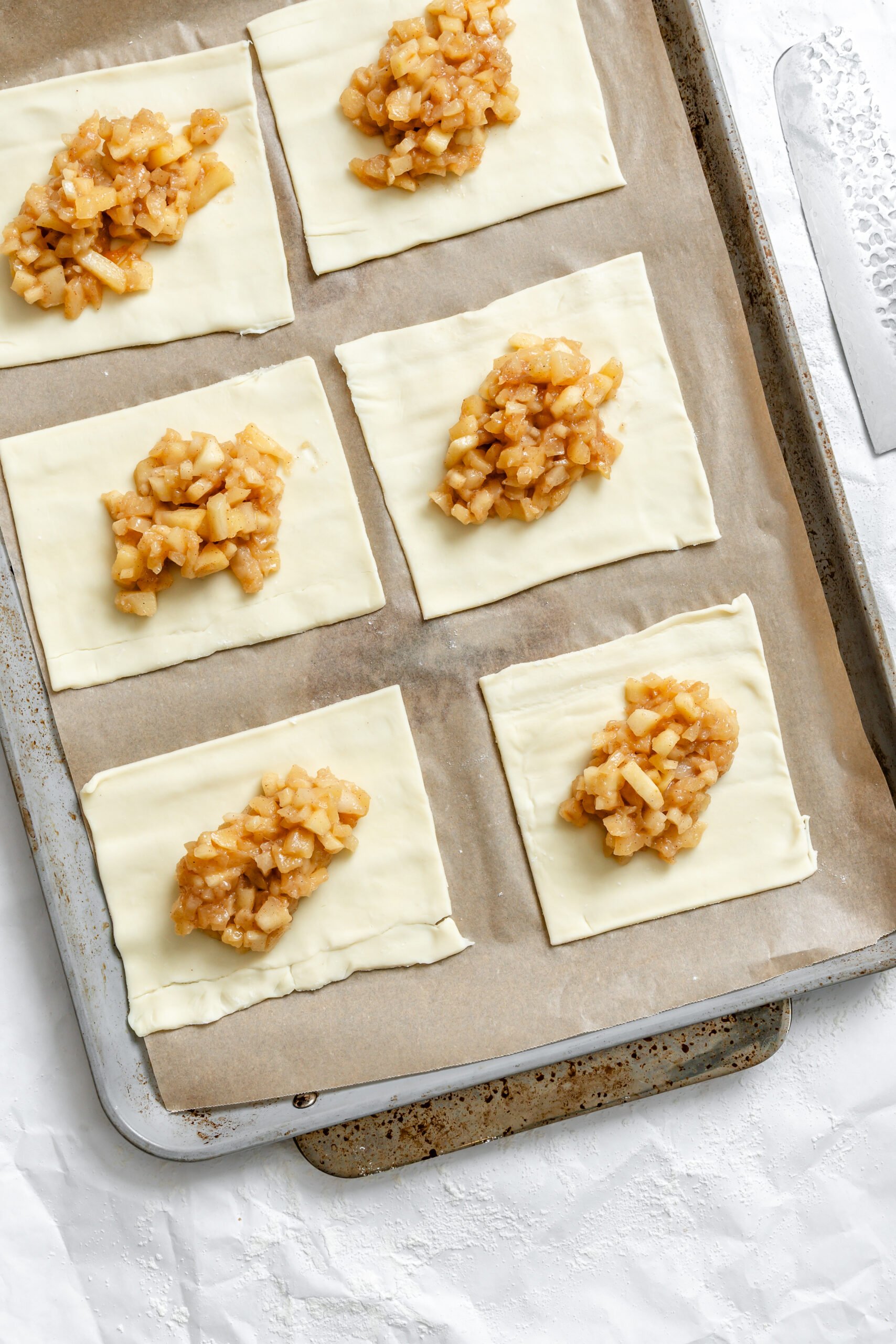 Process shot showing adding ingredients to puff pastry.