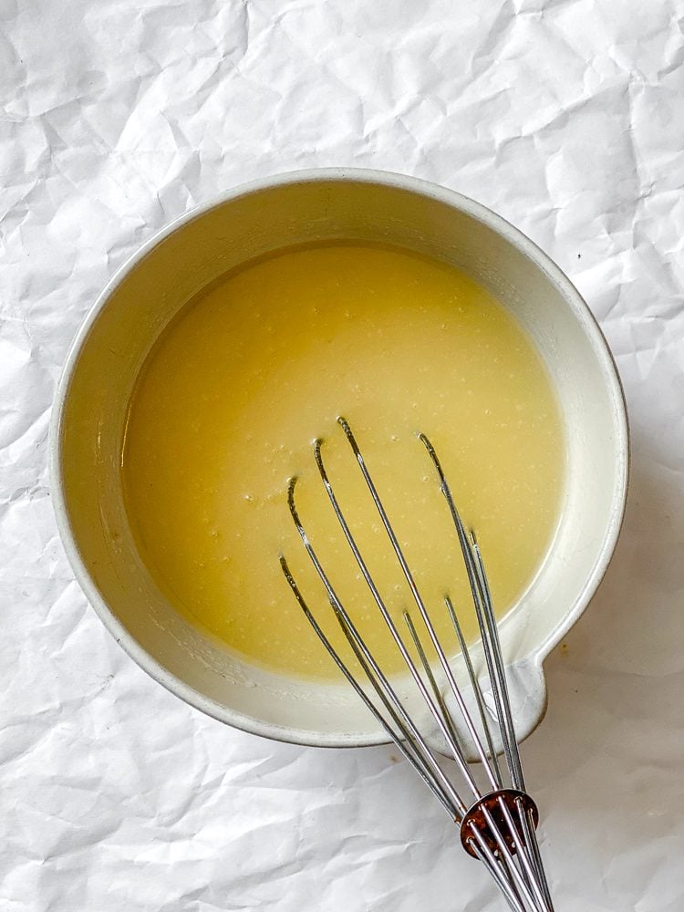 Process shot showing whisking ingredients together in a bowl.