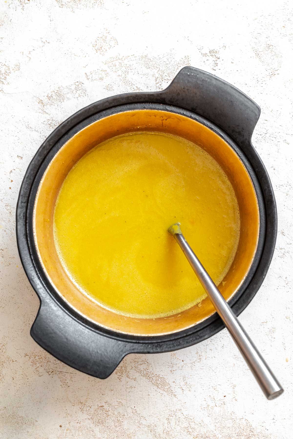 Process shot showing stirring ingredients in pot.