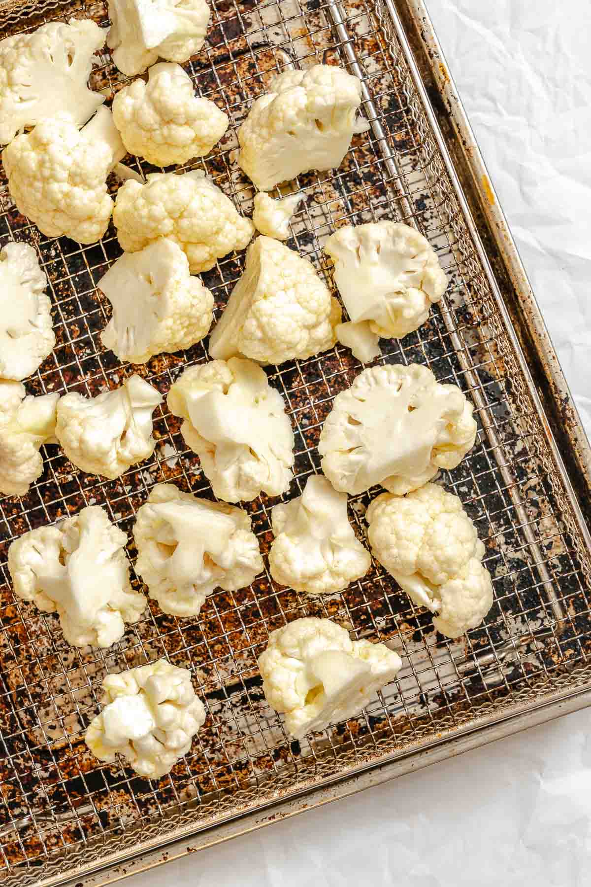 Process shot showing cauliflower on an air fryer rack.