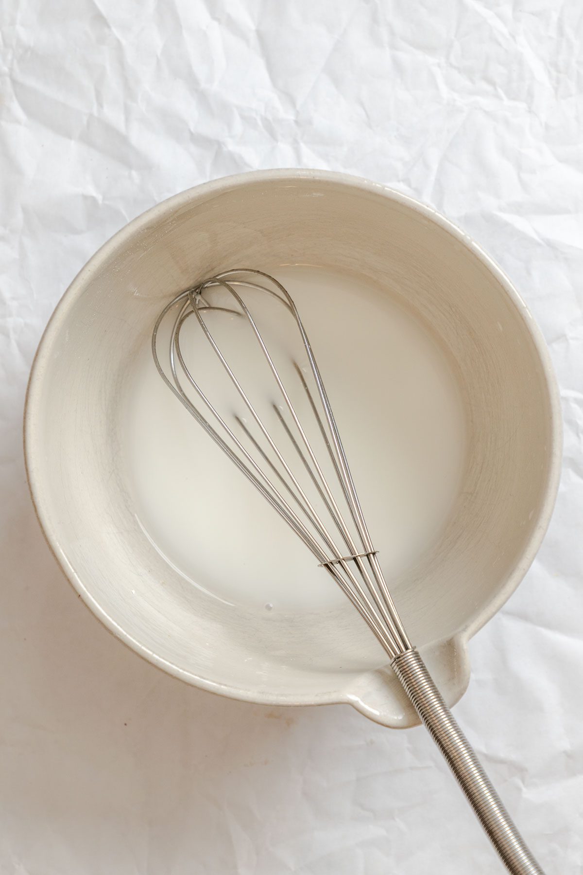 Process shot showing whisking corn starch slurry in bowl.