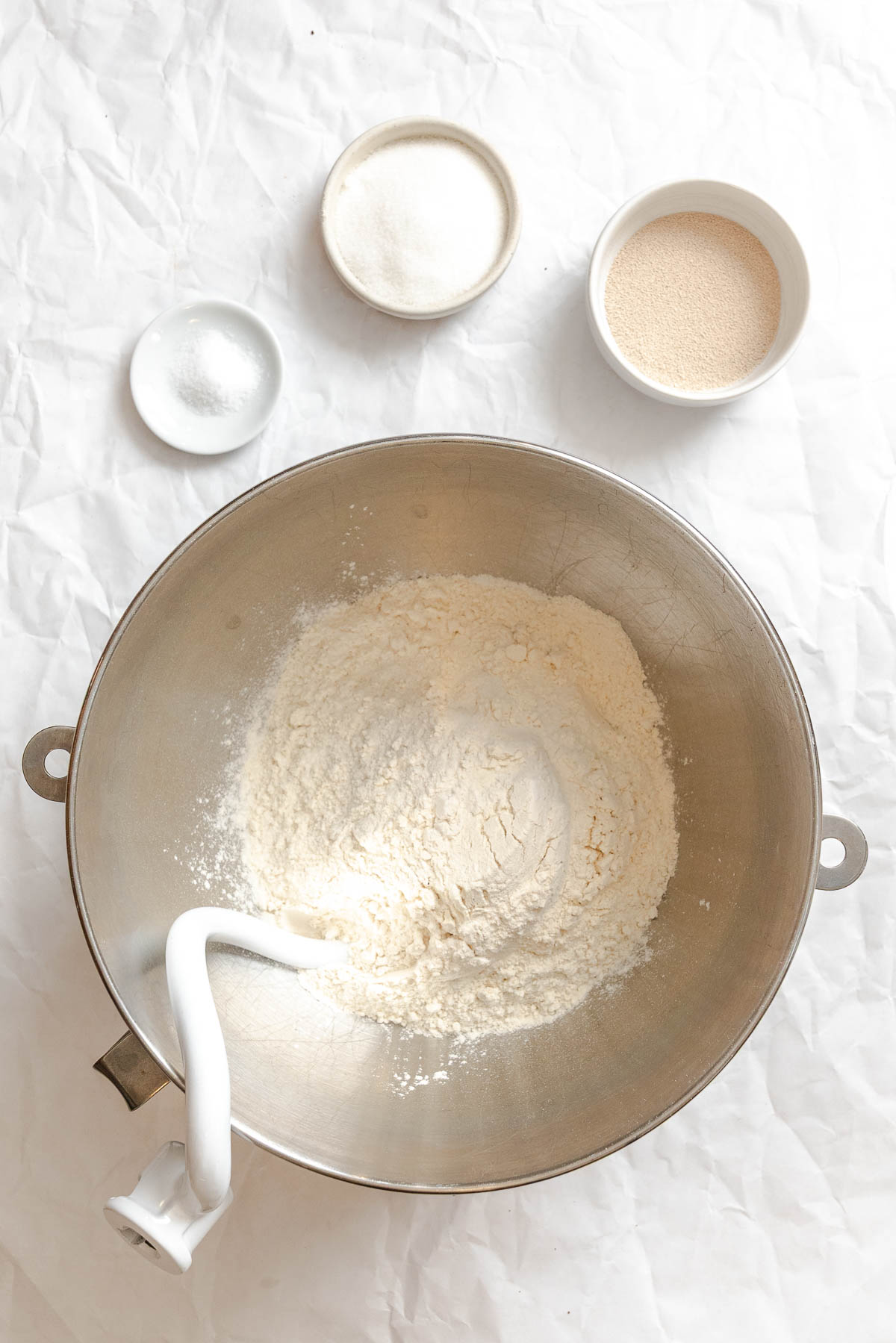Process shot showing using hook in bowl alongside several other ingredients.