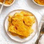 Completed Vegan Scalloped Potatoes on a plate on a white surface.
