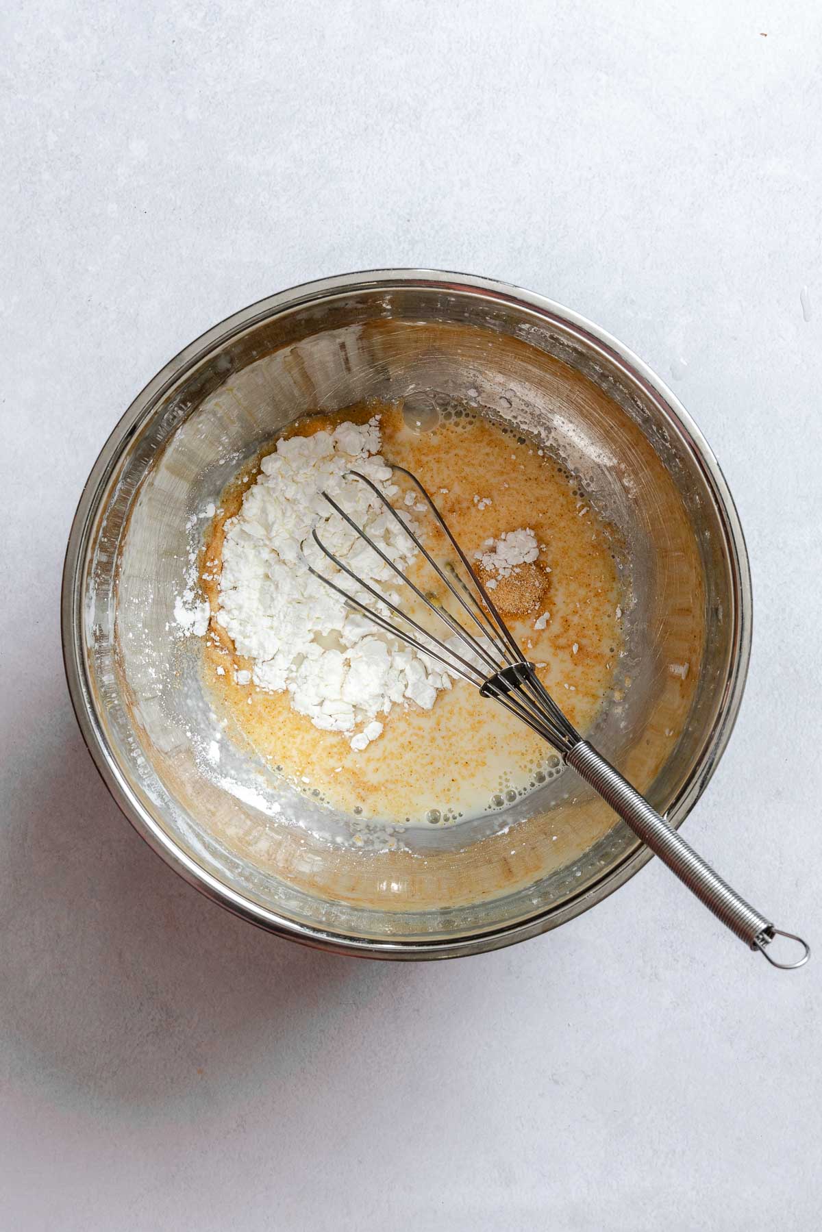 Process shot showing whisking ingredients in a bowl.