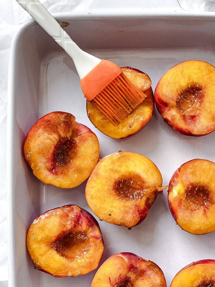 Process shot showing brushing mixture onto peaches.
