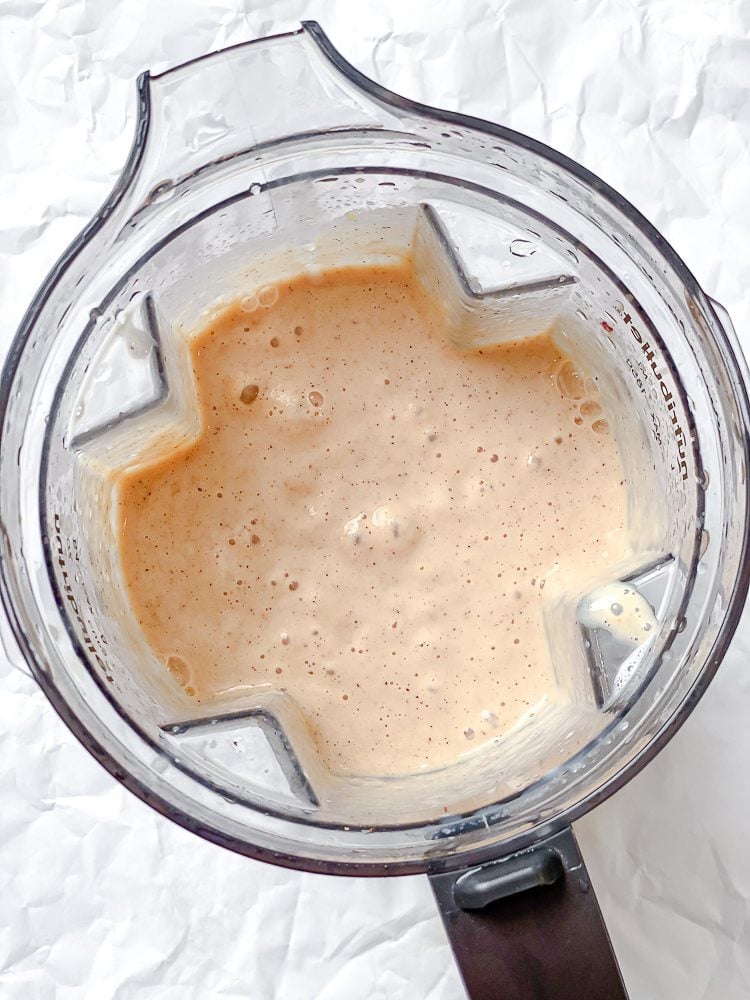 Process shot showing ingredients being blended in blender.