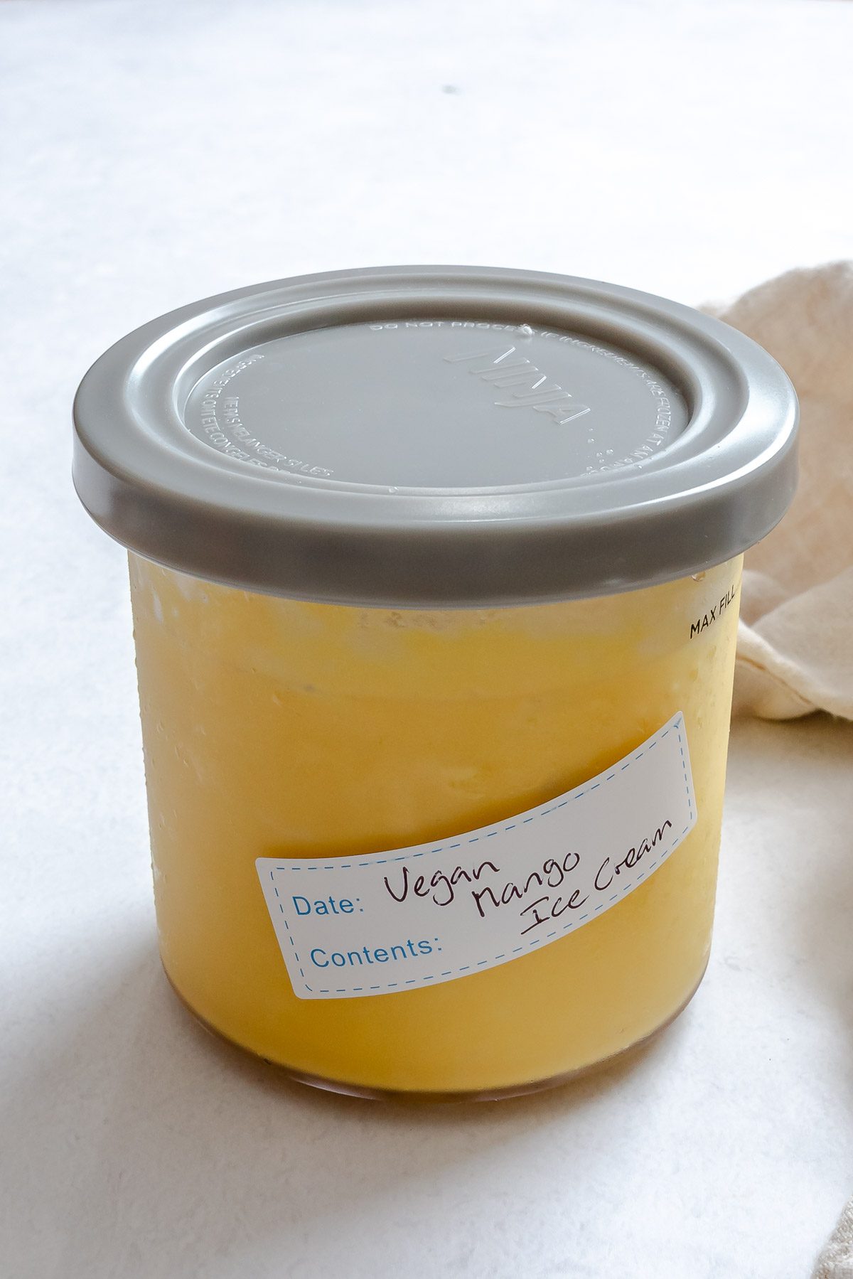 Completed Vegan Mango Ice Cream (Ninja Creami) in a storage container.