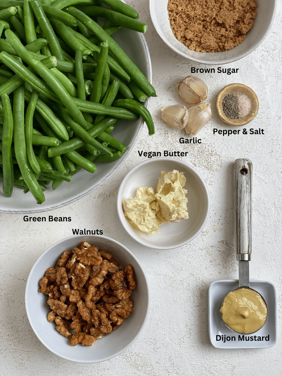 Ingredients for Brown Sugar Green Beans [No Bacon] measured out on a white surface.
