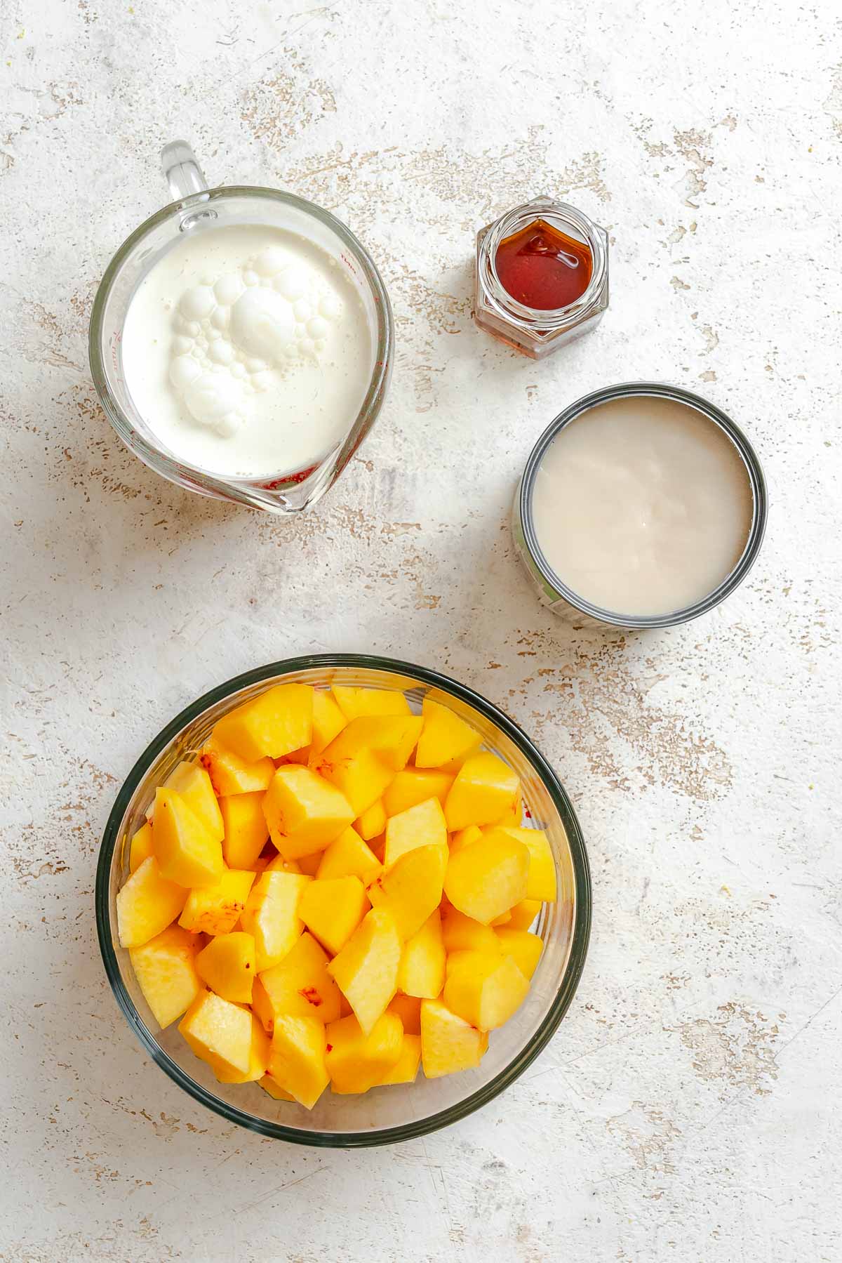 Ingredients for Vegan Peach Ice Cream (Ninja Creami) measured out on a white surface.