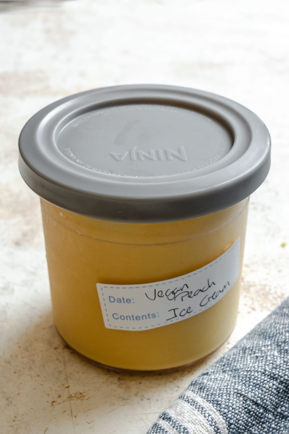 Completed Vegan Peach Ice Cream (Ninja Creami) in a storage container.