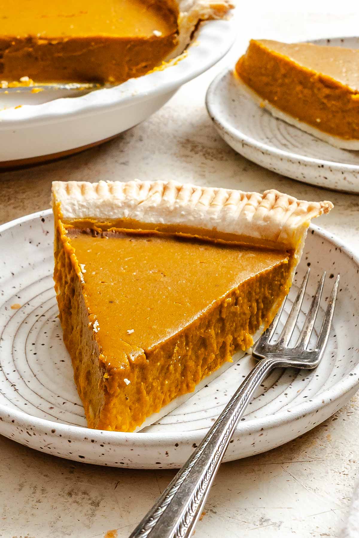 Completed Vegan Pumpkin Pie (Easy + GF Optional) slice on a white surface.
