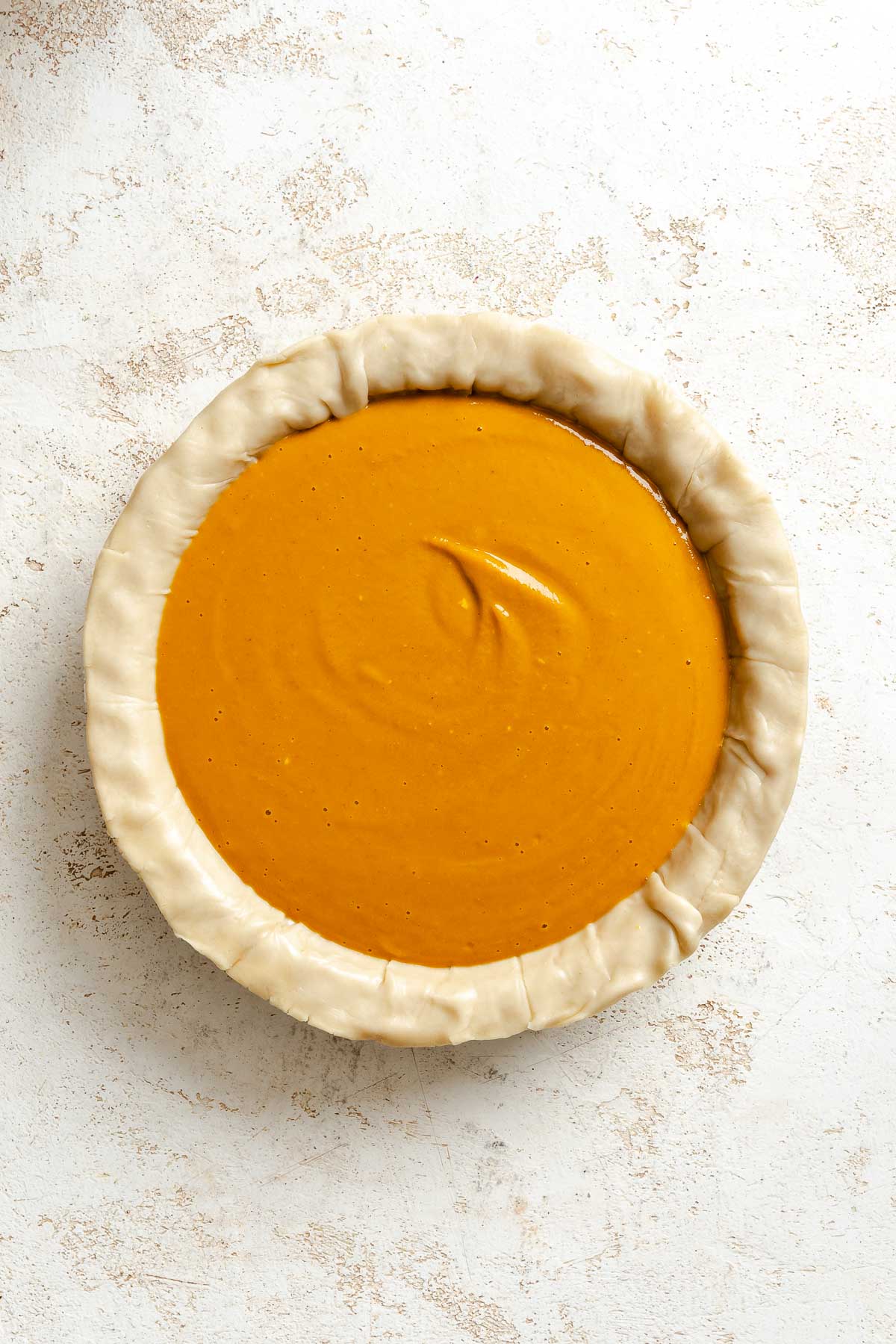 Process shot showing filling added to pie crust.