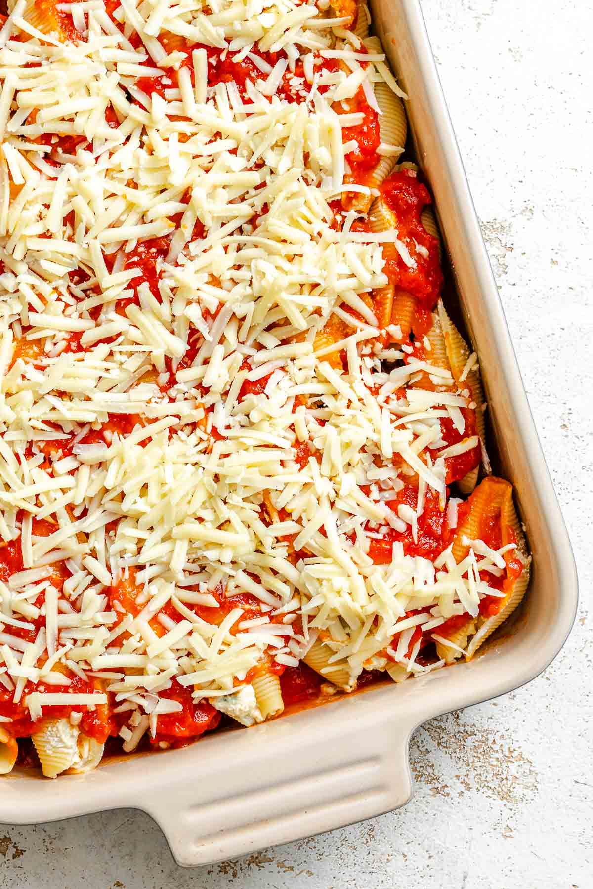 Process shot showing pre-baked Vegan Stuffed Shells in baking dish.