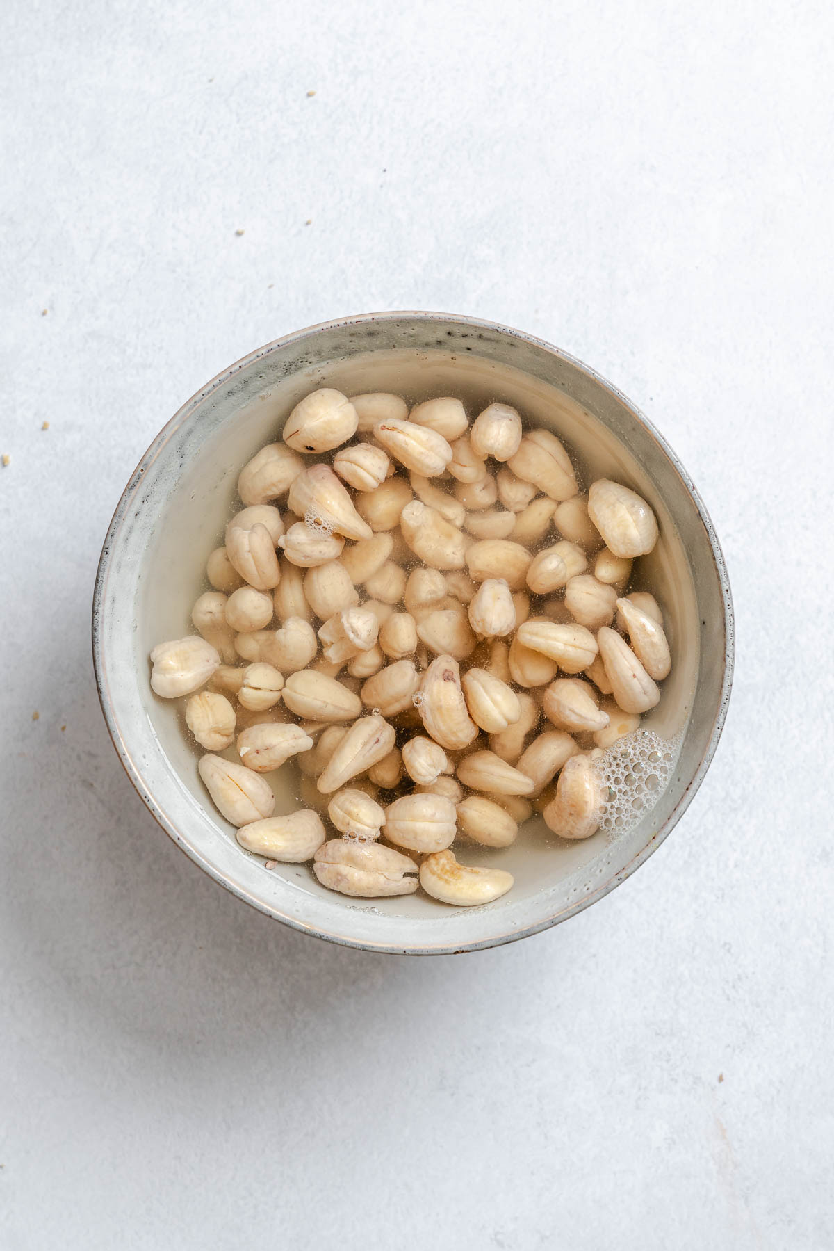 Process shot showing cashews in a bowl.
