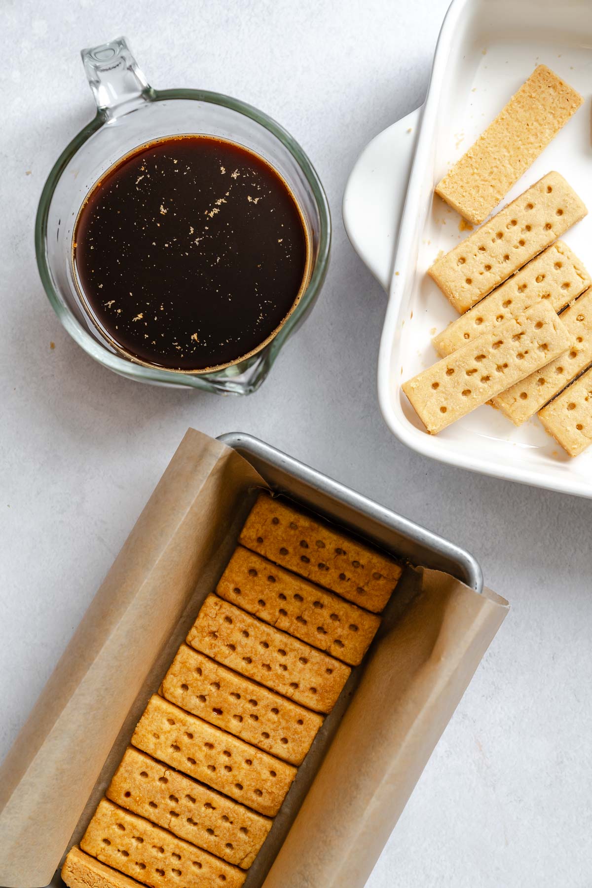 Process show showing assembling Easy Vegan Tiramisu on white surface.
