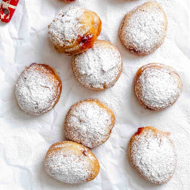 Completed Sufganiyot (Hannukkah Jelly Donuts) on white surface.