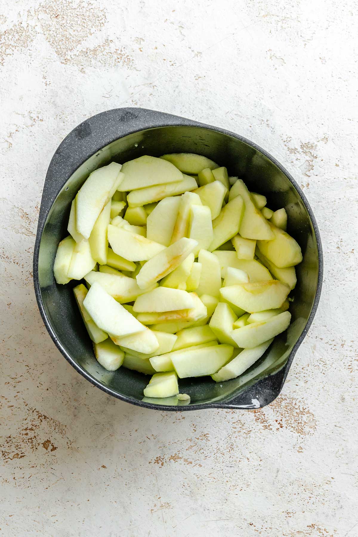 Process shot showing apples in a pot.