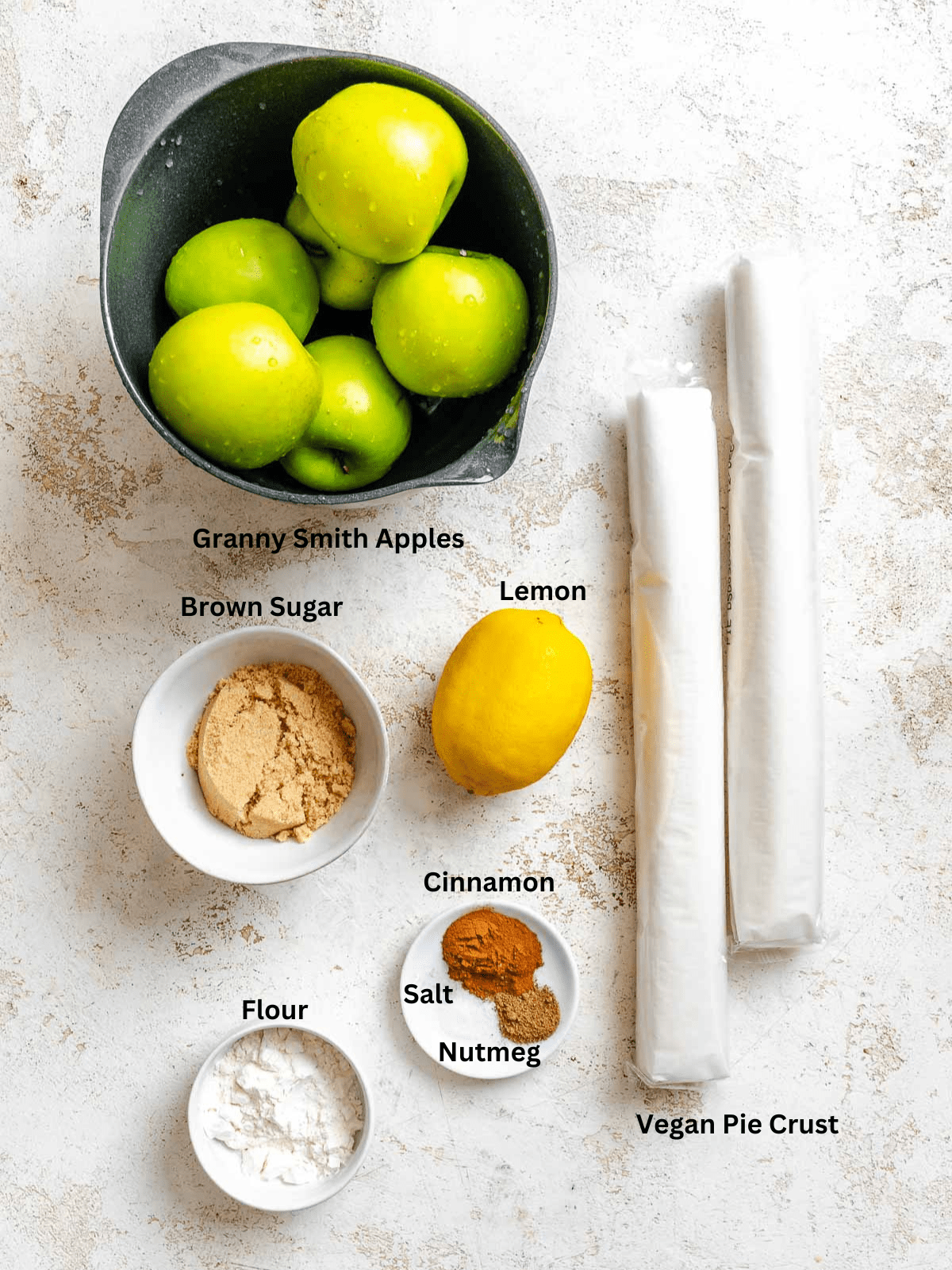 Ingredients for Easy Vegan Apple Pie measured out on a white surface.