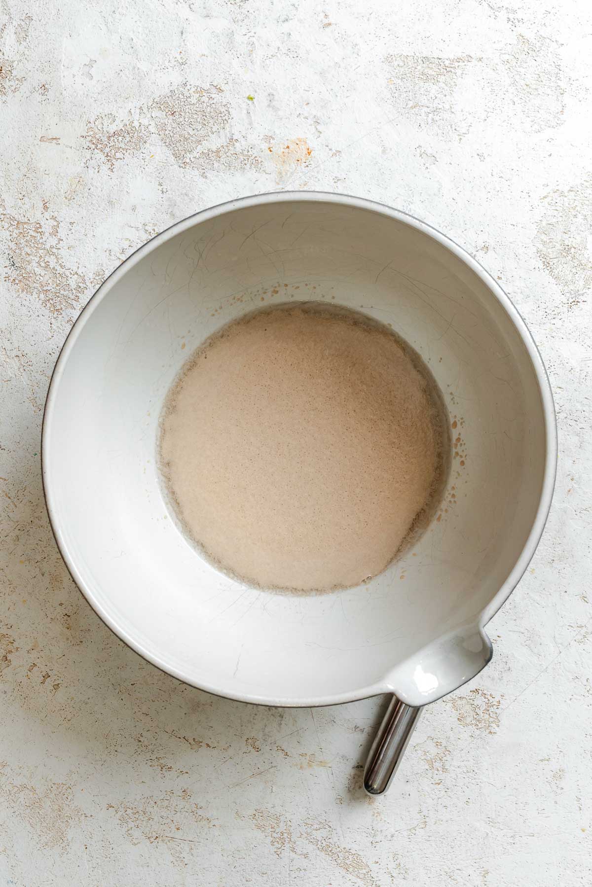 Process shot showing sugar water mixed in a bowl.