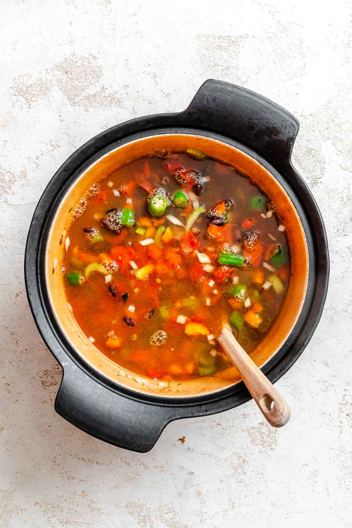 Process shot showing stirring ingredients in pot.