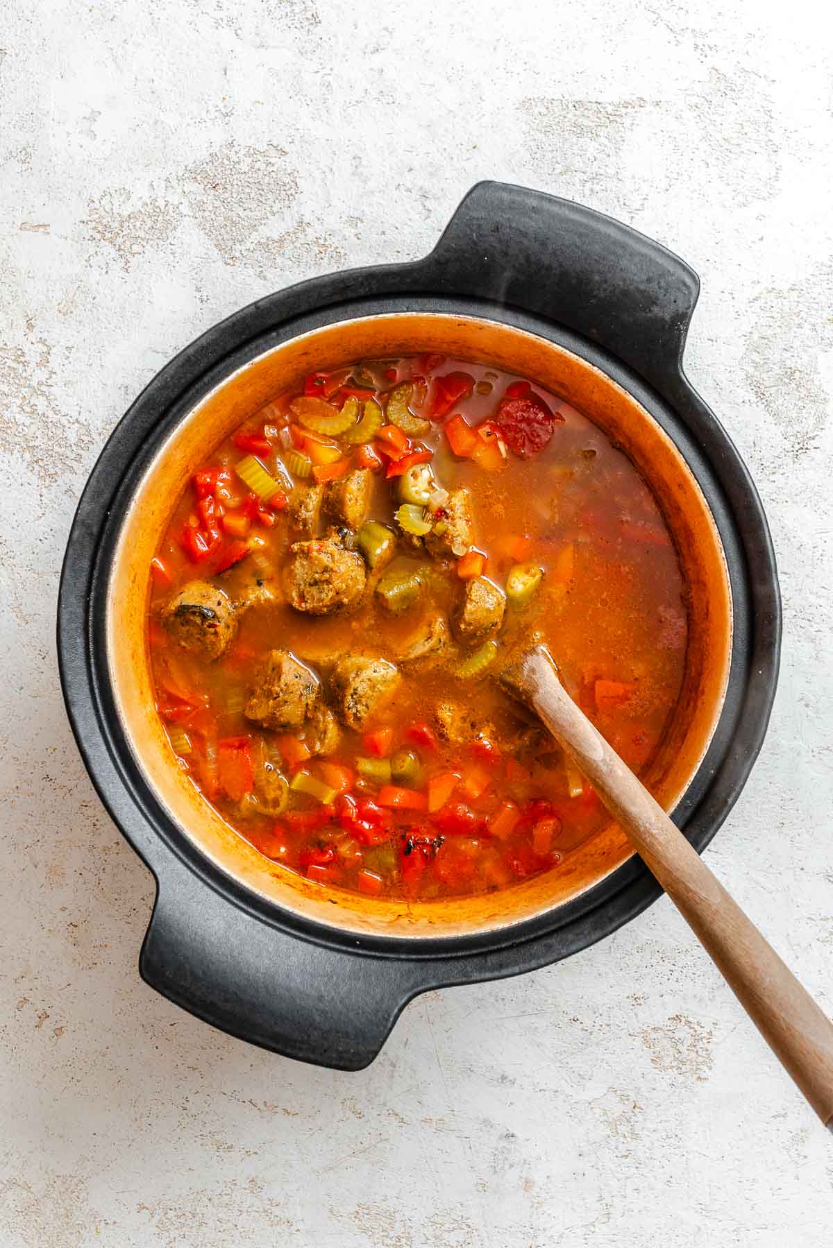 Process shot showing stirring ingredients in pot.