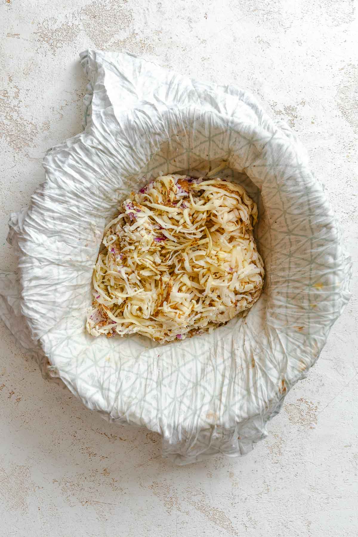 Process shot showing ingredients in a bowl lined with a paper towel.