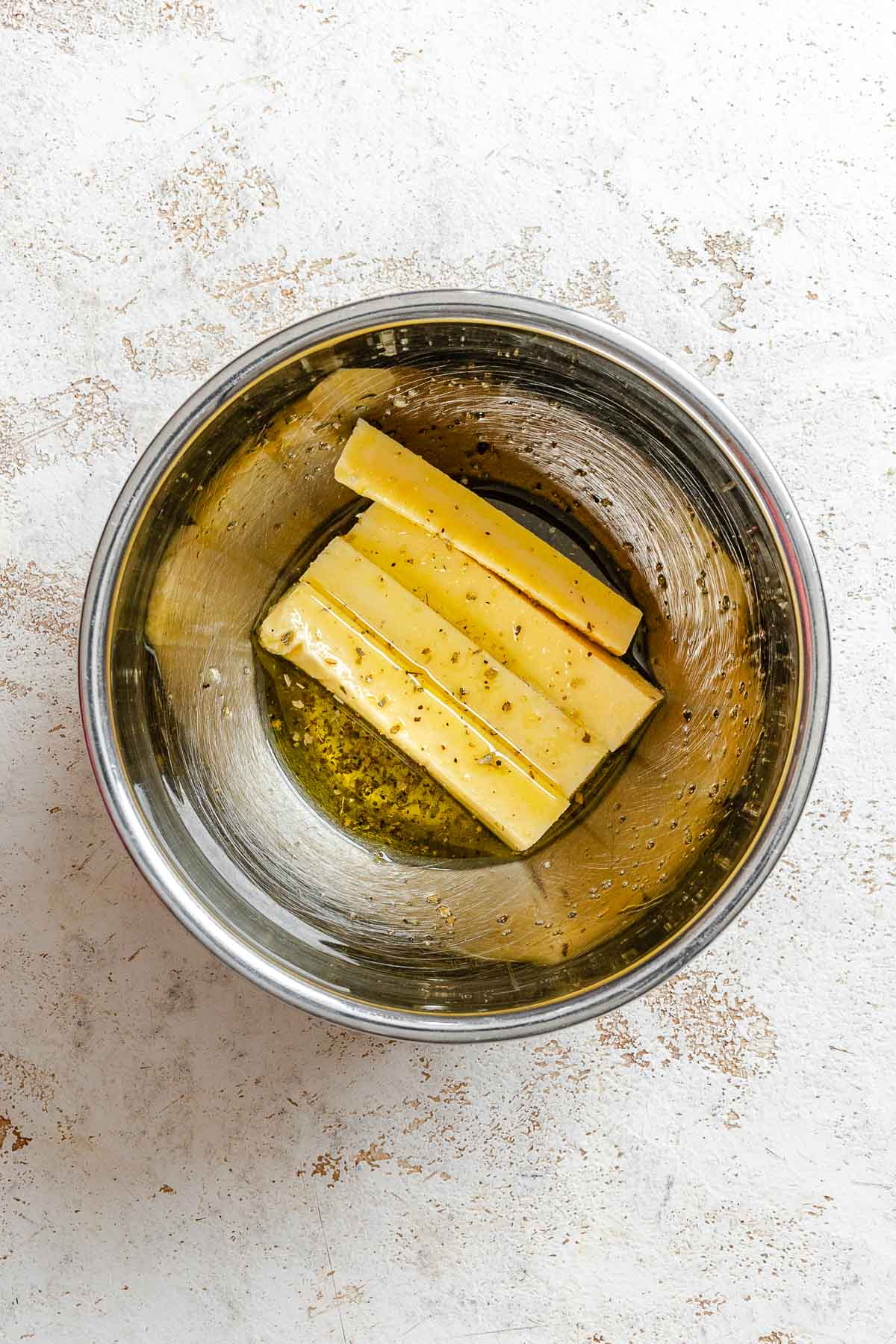 Process shot showing adding polenta to bowl of seasonings.