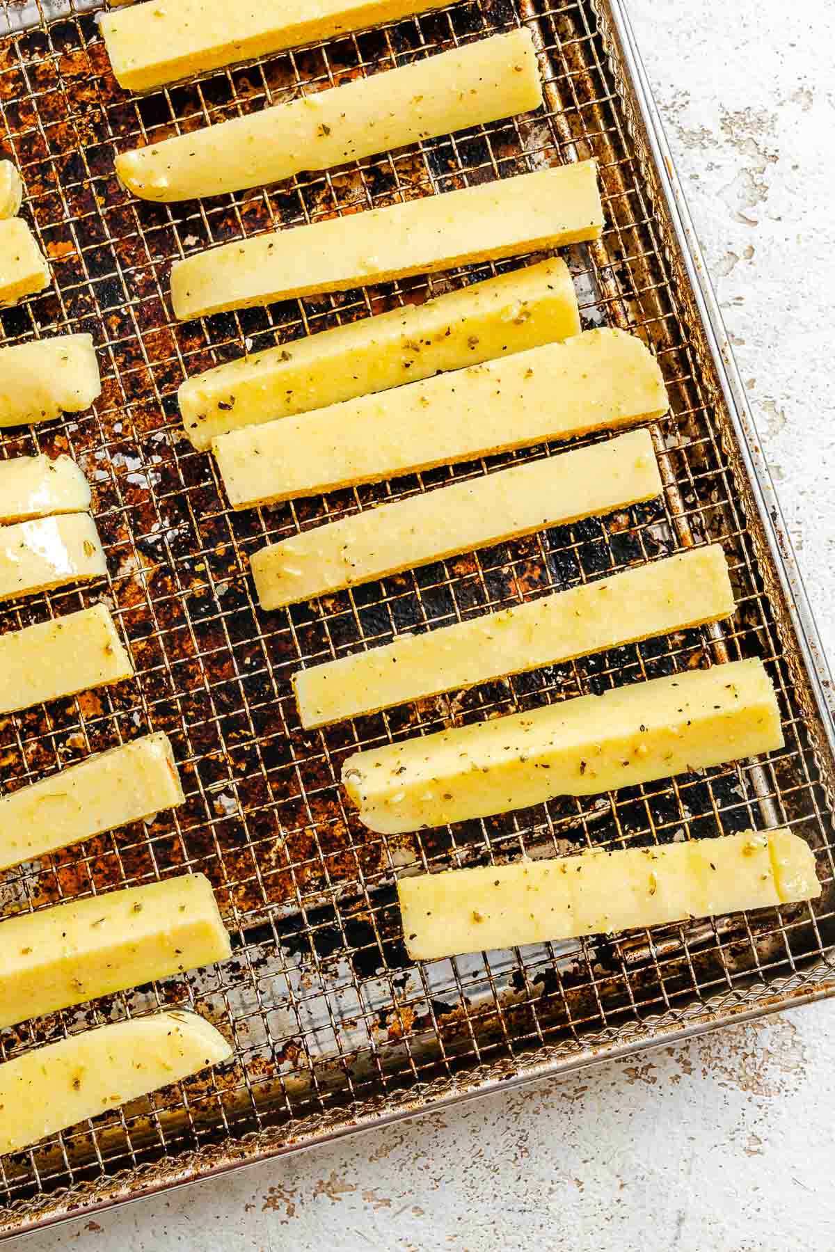 Process shot showing polenta added to air fryer tray.