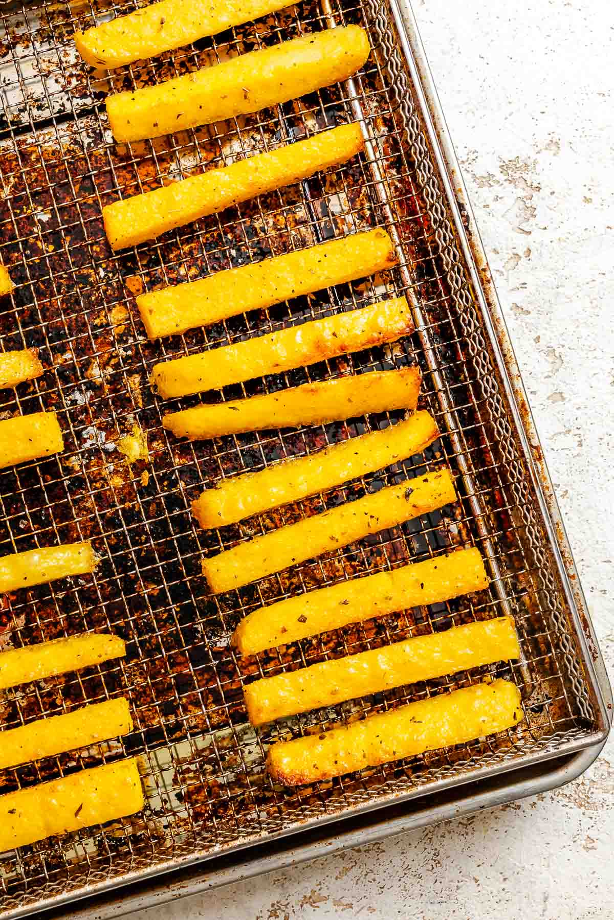 Process shot showing post air fried polenta fries on tray.