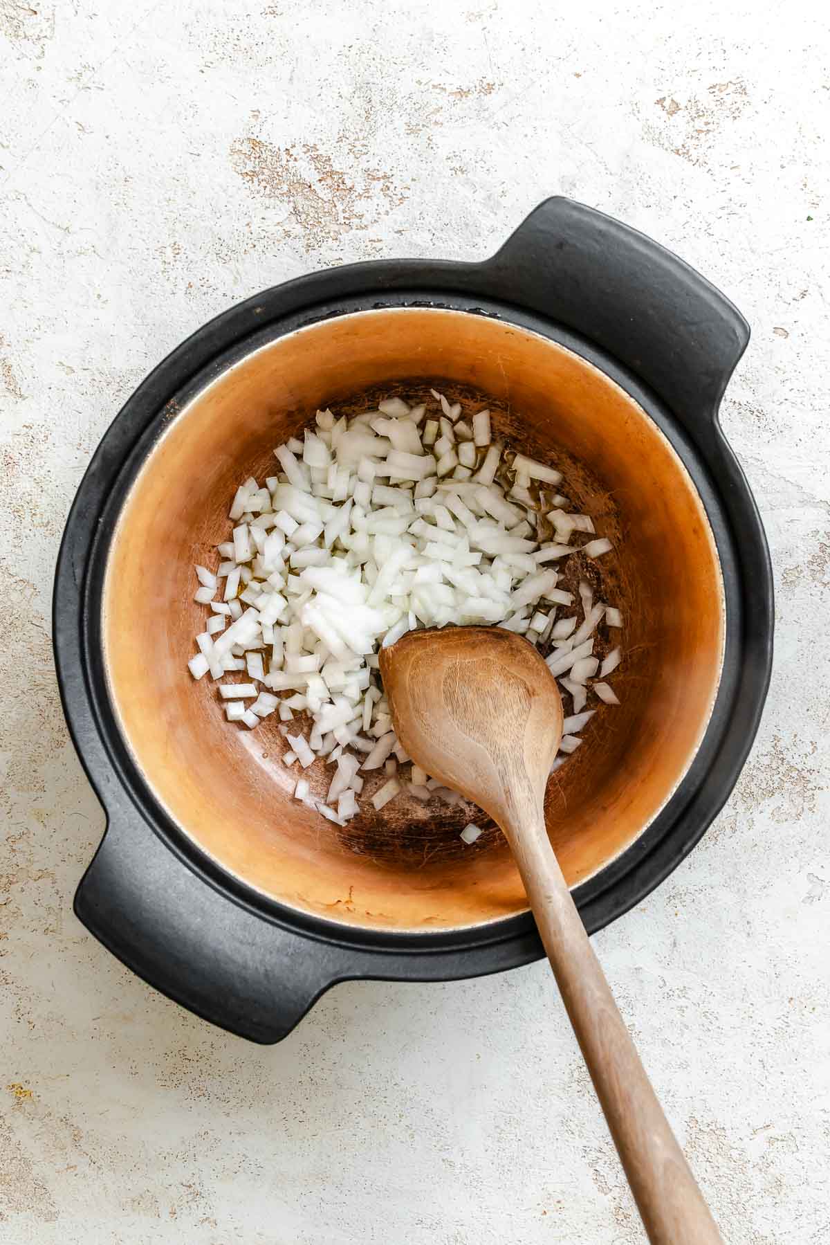 Process shot showing stirring ingredients in pot.