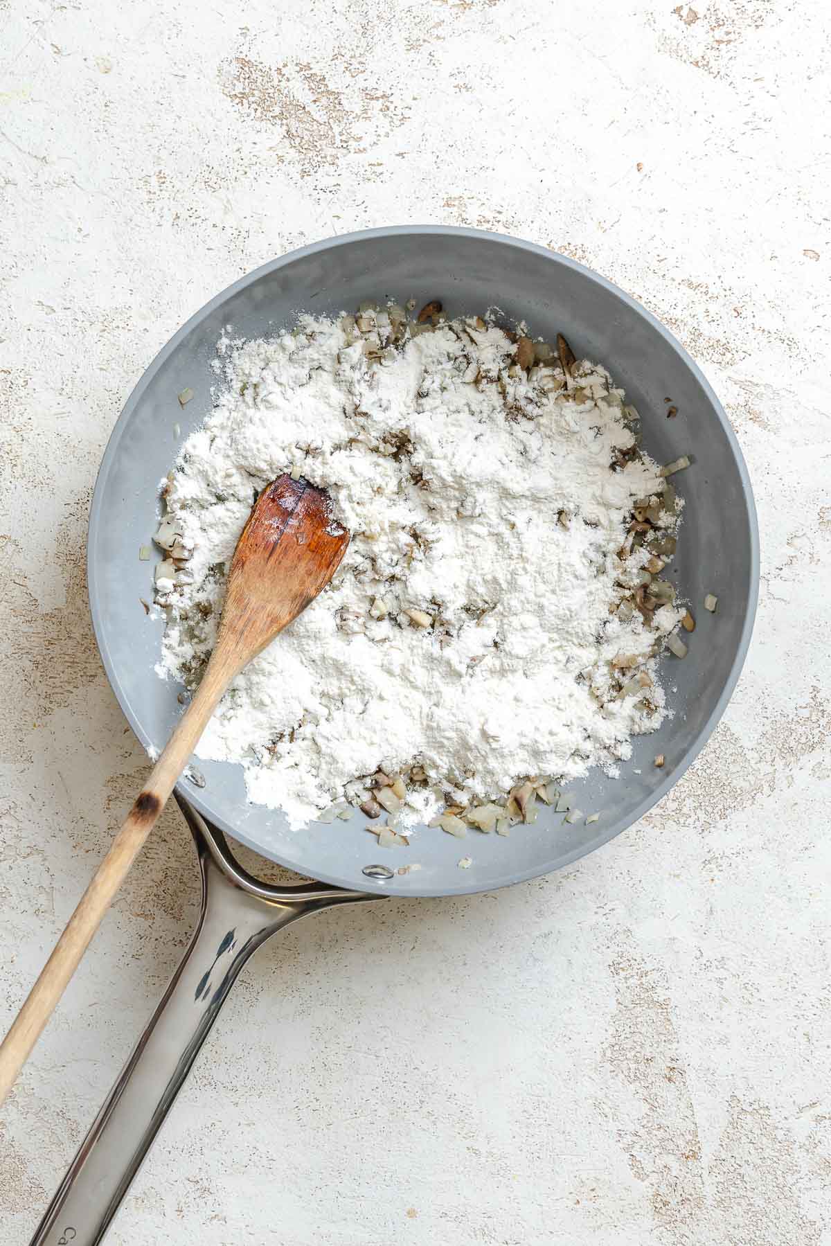 Process shot showing stirring ingredients in a pan.