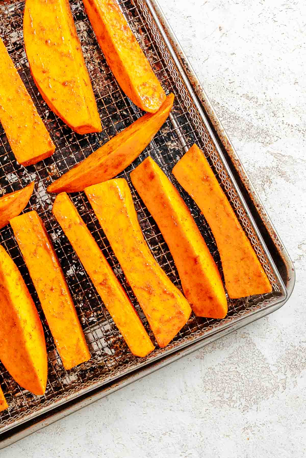 Process shot showing fries added to air fryer tray.