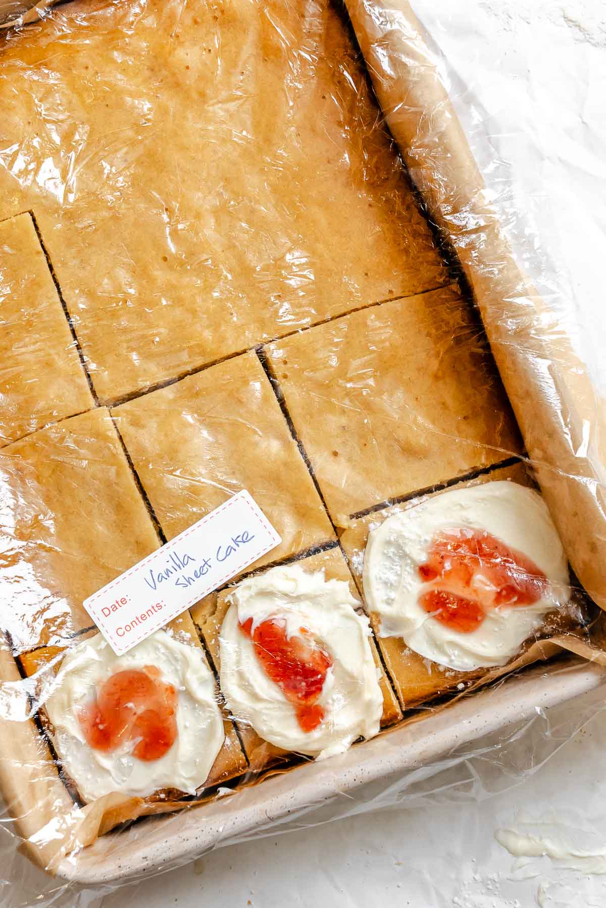 Completed and sliced Vegan Sheet Cake (Vanilla) in a storage container.