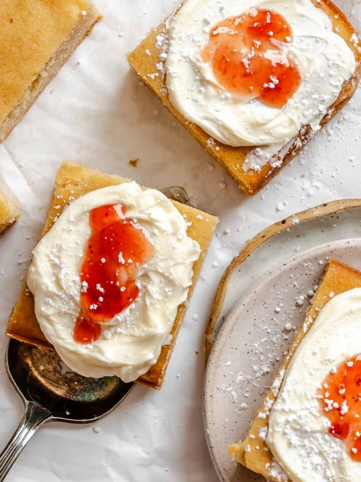 Completed and sliced Vegan Sheet Cake (Vanilla) on a white surface.