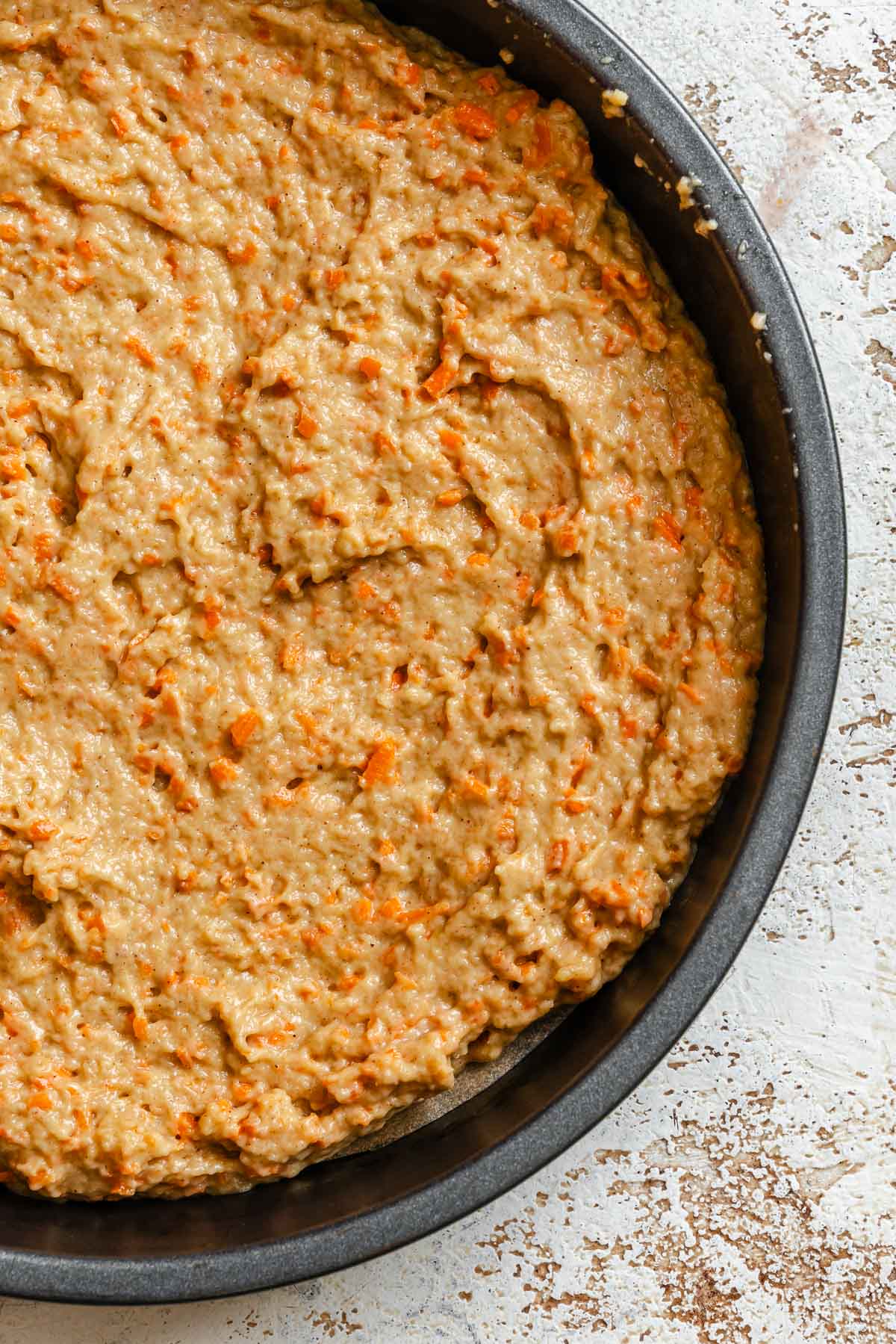 Process shot showing batter added to cake pan.