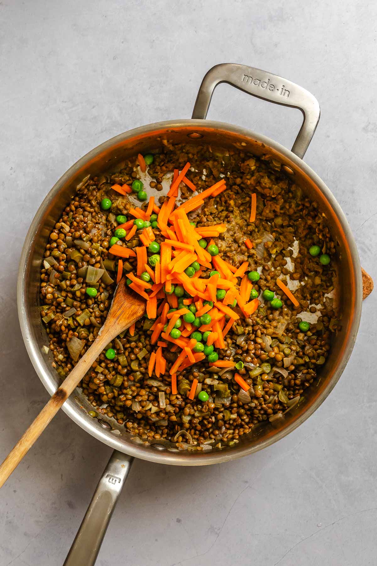 Process shot showing veggies added to pot.