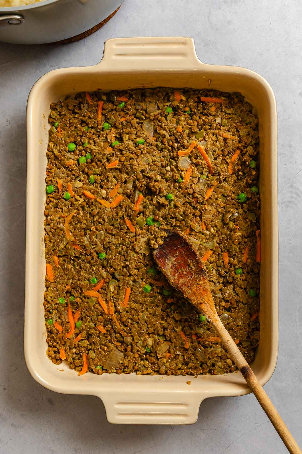 Process shot showing ingredients added to casserole baking dish.