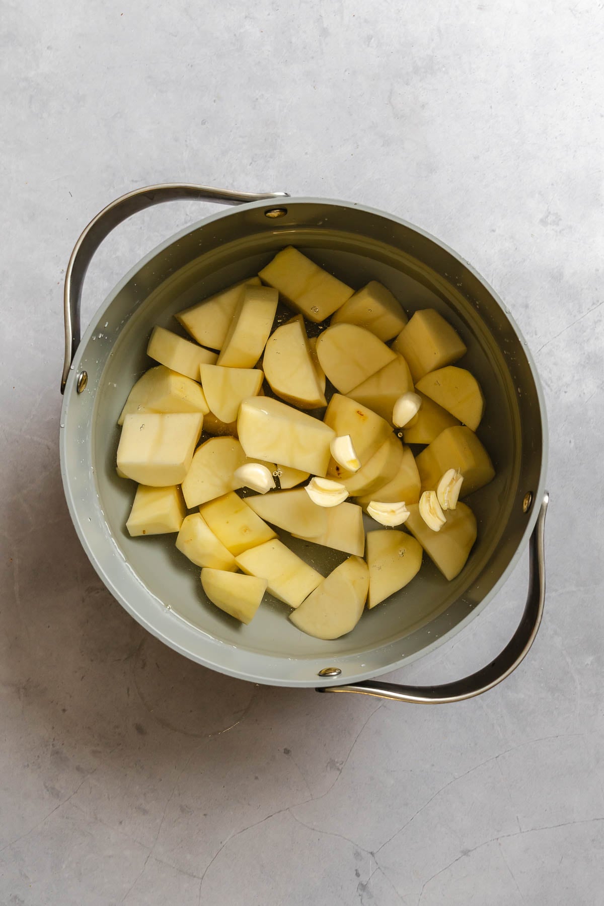 Process shot showing potatoes in a pot.