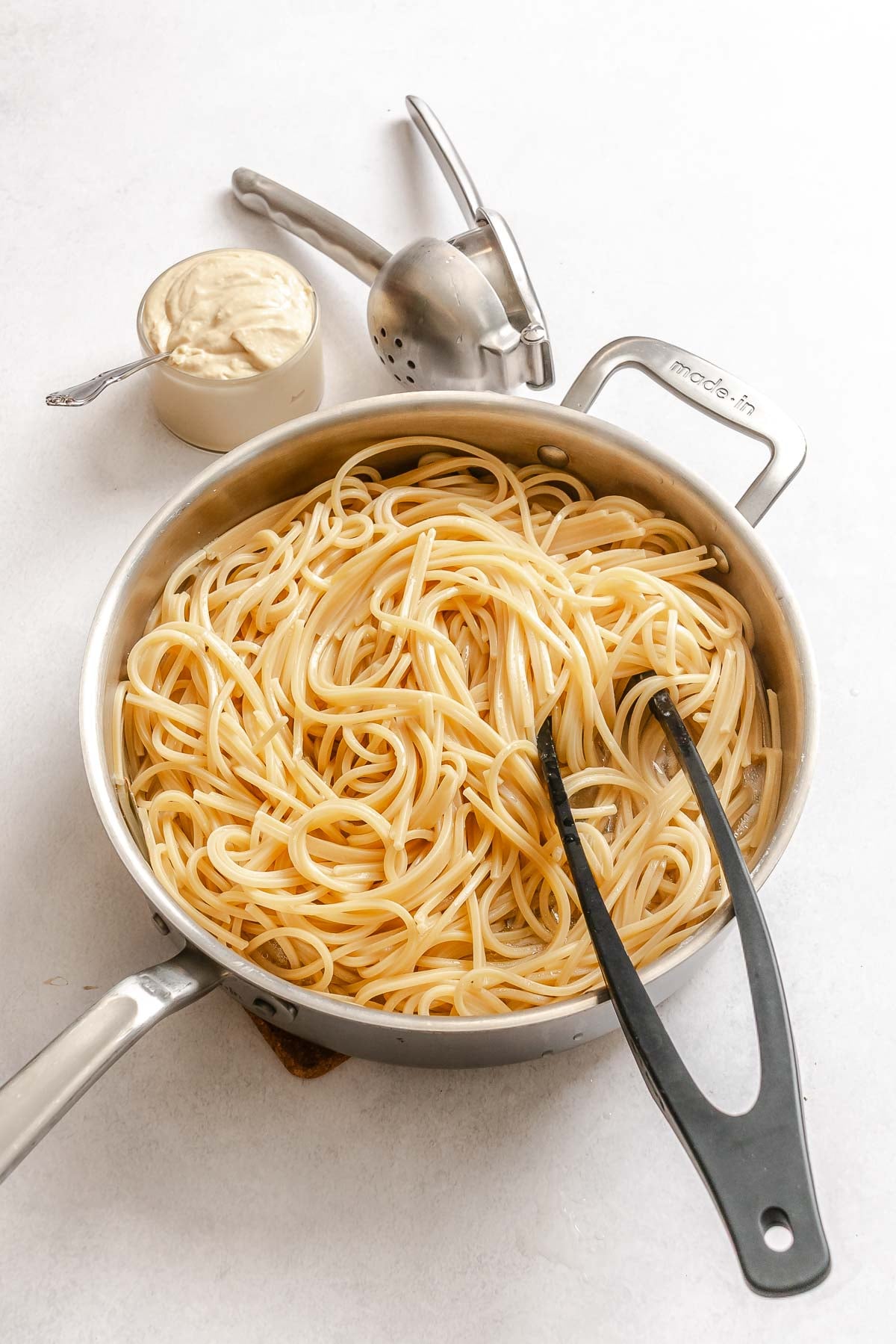 Process shot showing cooking noodles in pan.
