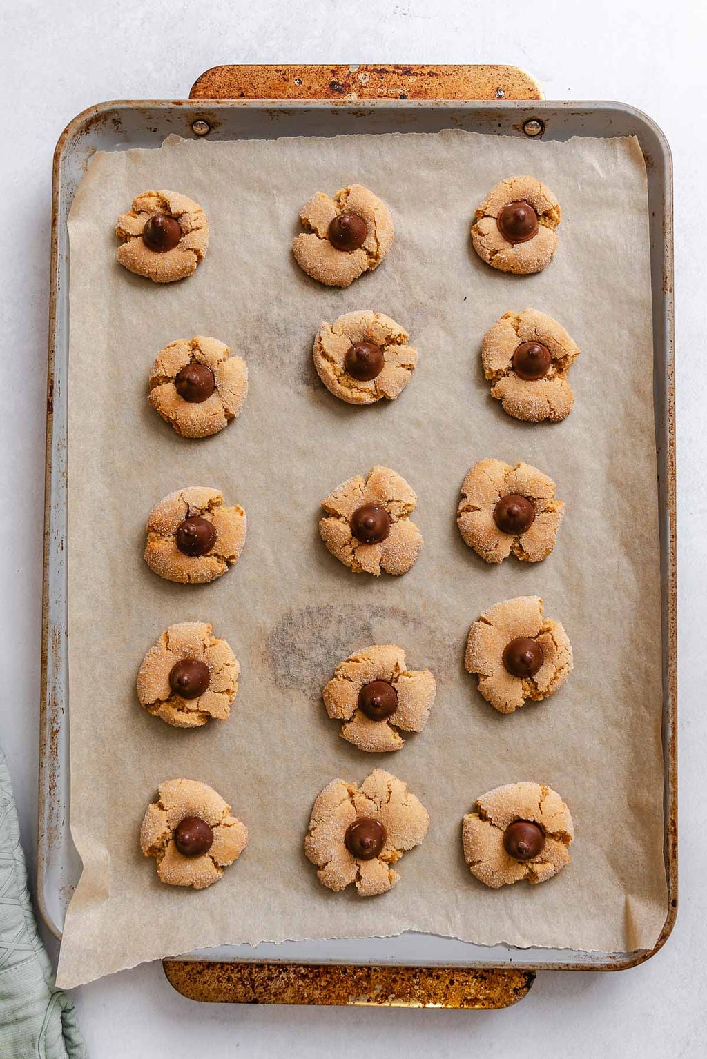 Process shot showing adding vegan chocolate to cookies on baking sheet.