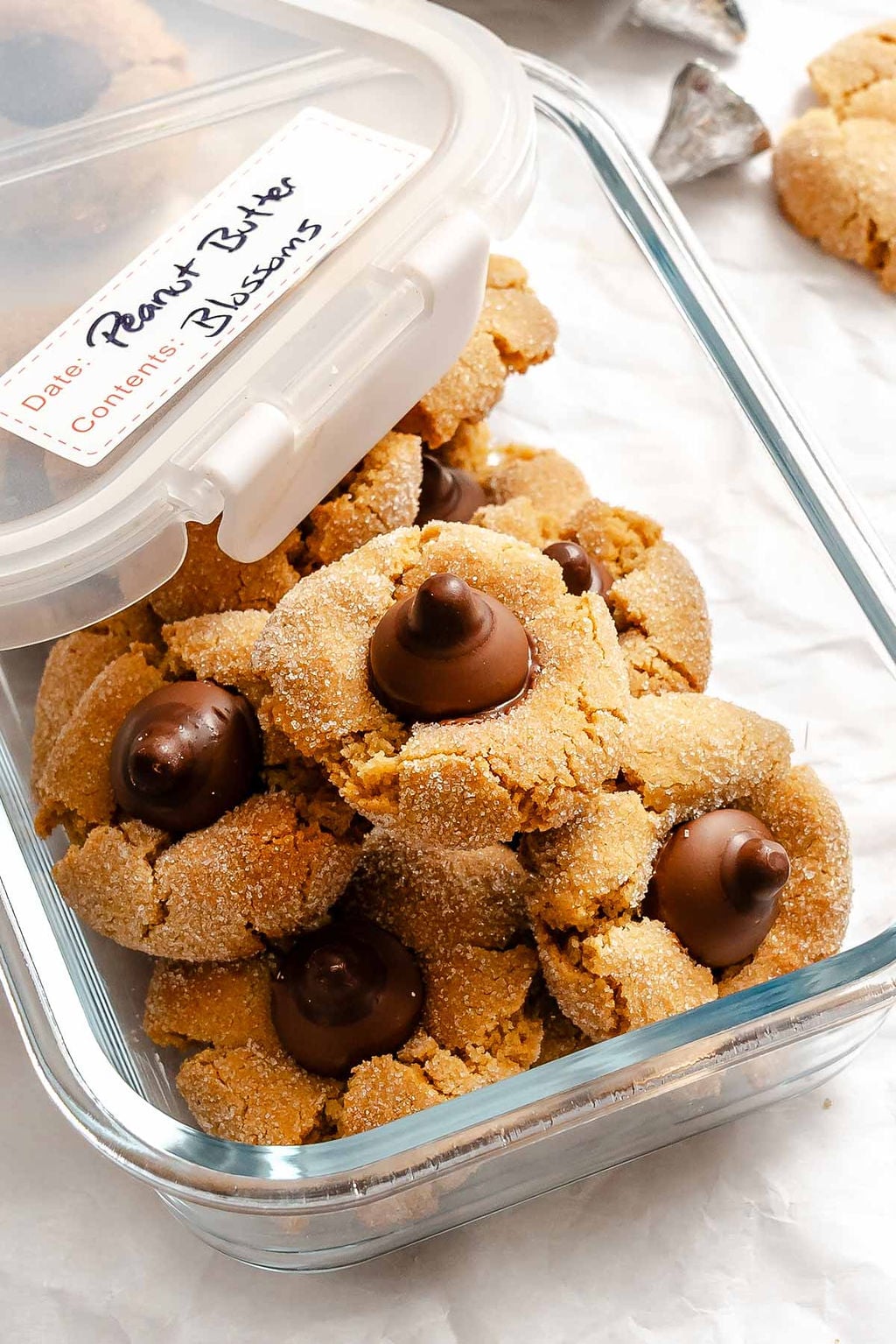 Completed Peanut Butter Blossoms in a storage container.