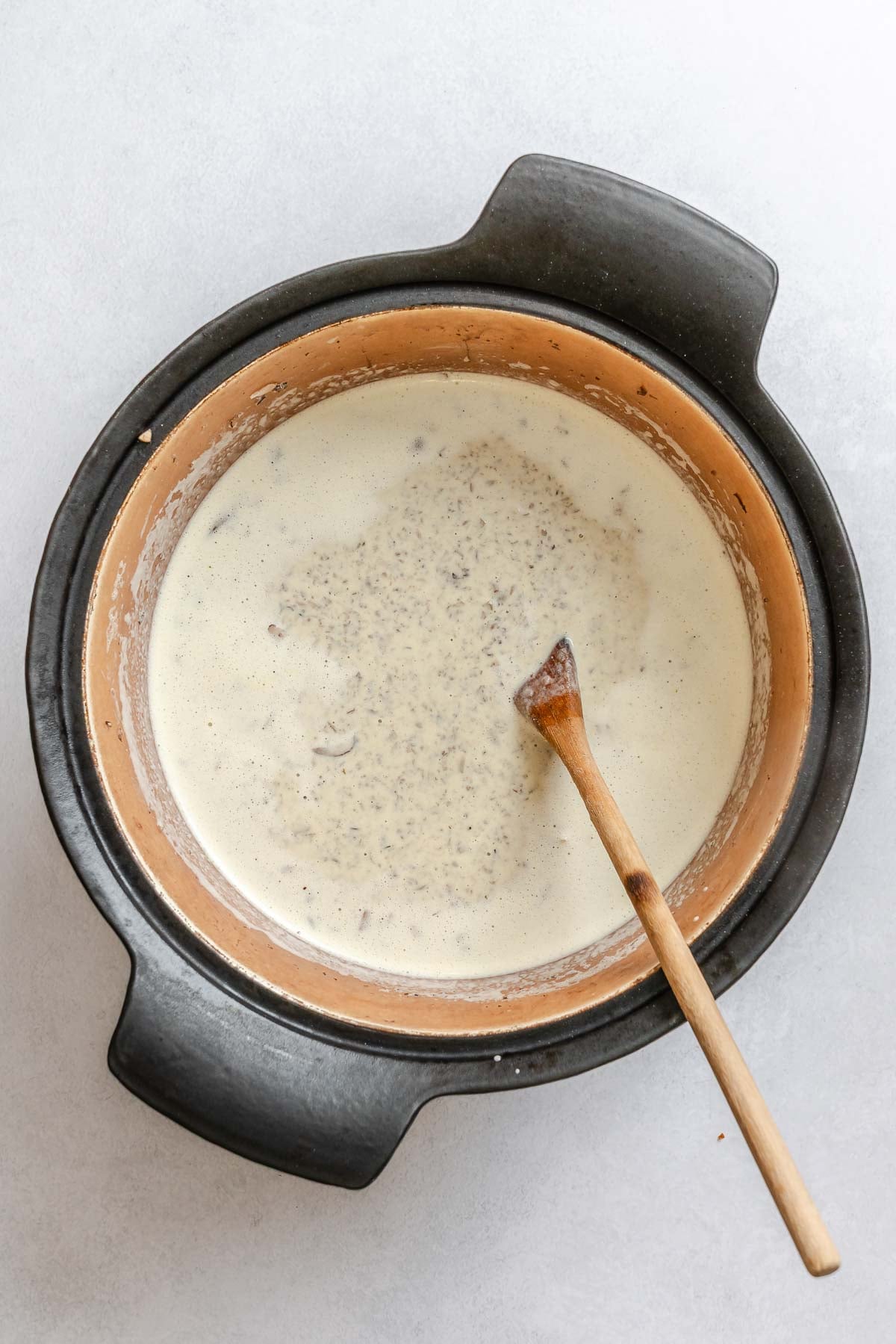 Process shot showing stirring ingredients in a pot.