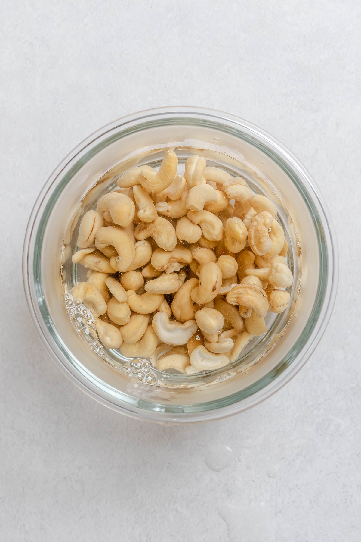 Process shot showing cashews softening in a bowl.